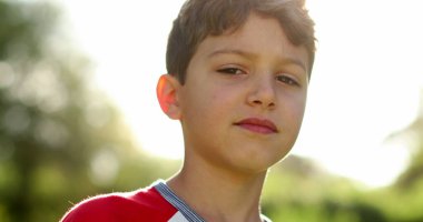 Çocuk yüzü açık havada parlayan merceklerde gülümsüyor.