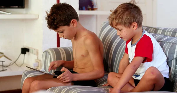 Gyermekek Otthon Ülnek Kanapén Játszik Tabletta Eszköz — Stock Fotó