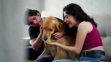 Mutlu çift evde labrador köpeğiyle eğleniyor. 