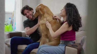 Mutlu çift evde labrador köpeğiyle eğleniyor. 