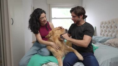 Mutlu çift evde labrador köpeğiyle eğleniyor. 