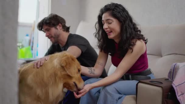 一对快乐的夫妇在家里和可爱的拉布拉多狗玩得开心 — 图库视频影像