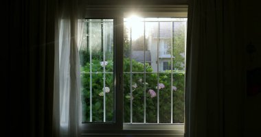 Gün batımında altın saat boyunca ev penceresinden yansıyan parlak mercek.