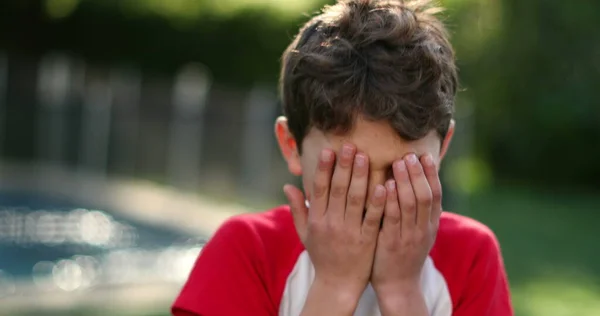 Расстроенный Мальчик Закрывает Лицо Рукой Снаружи — стоковое фото