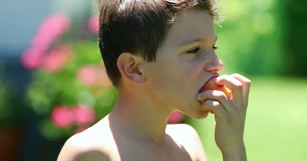 Pensiv Ung Pojke Äter Hälsosamt Frukt Mellanmål Utanför Bakgården Kontemplativt — Stockfoto