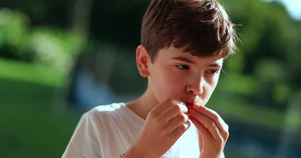 外で果物を食べる幼児 食べ物の考えに吸収された思慮深い少年 — ストック写真