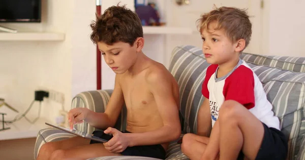 Παιδιά Στον Καναπέ Στο Σπίτι Παίζοντας Συσκευή Tablet — Φωτογραφία Αρχείου