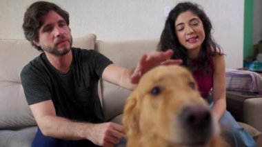 Mutlu çift evde labrador köpeğiyle eğleniyor. 