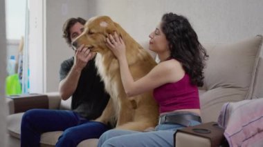 Mutlu çift evde labrador köpeğiyle eğleniyor. 
