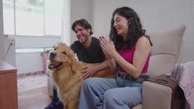Mutlu çift evde labrador köpeğiyle eğleniyor. 