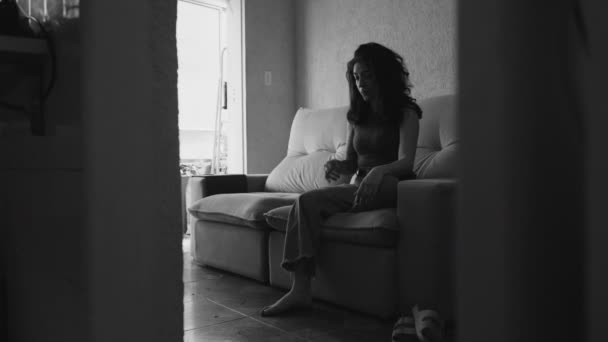Δραματική Νεαρή Γυναίκα Κάθεται Στον Καναπέ Στο Σπίτι Νιώθοντας Μόνη — Αρχείο Βίντεο