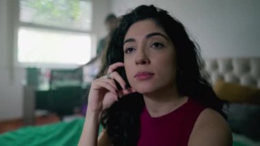 Düşünceli genç bir kadın yatakta otururken düşünüyor. 30 'lu yaşlarda düşünceli bir kadın yüzü.