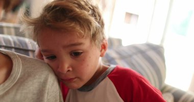 Sabah uyanan bir çocuk, yukardan bakan bir kardeş omzu, gerçek bir bebek suratı.