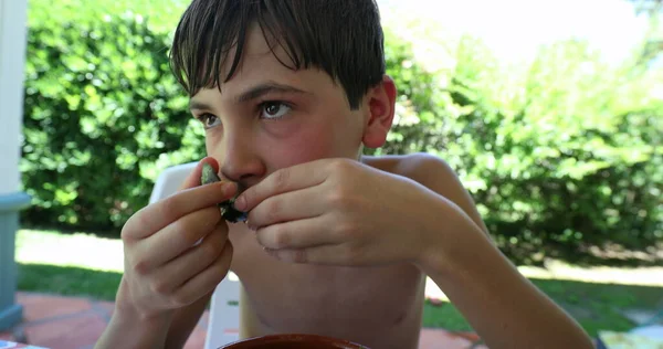 夏の日は外のボウルに魚介類のムール貝を食べる子供 若い男の子は口を食べる — ストック写真
