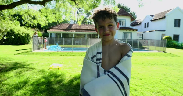 タオルに包まれたプールの隣に立つハンサムな子供 — ストック写真