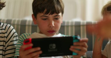 Evde elinde tablet olan çocuk oyun oynuyor