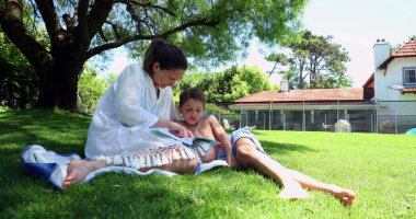 Anne, evde ev ödevi yaparken sıkılmış çocuğa yardım ediyor.