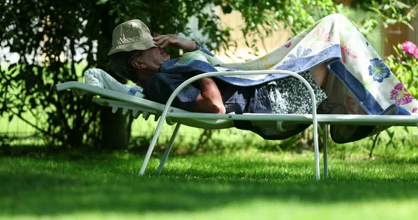 stock image Candid older man taking a break resting outside preparing to sleep. Senior retired man taking a nap