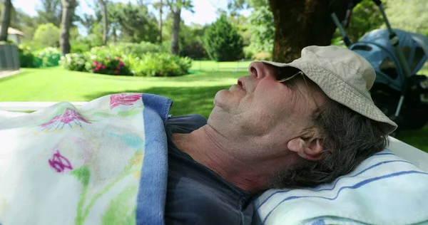 Exhausted older man sleeping during summer day