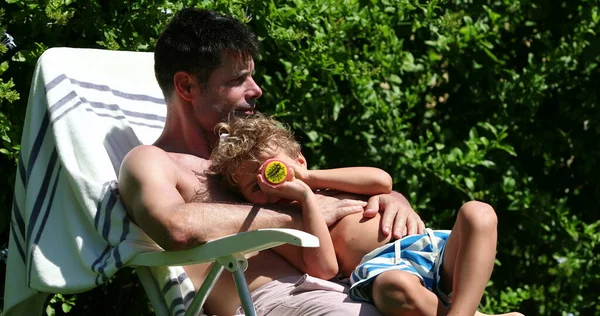 아버지와 아들은 밖에서 햇빛을 받으며 작용한다 아버지의 가슴을 껴안고 어린이 — 스톡 사진