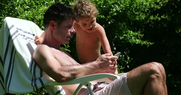 Candid Homem Tomando Banho Sol Fora Dando Smartphone Para Criança — Fotografia de Stock