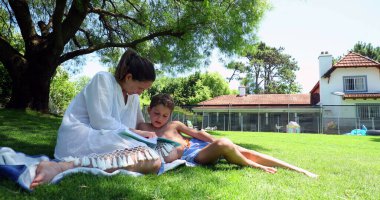 Anne ve babası çocuğuna evlerinin bahçesinde yardım ediyor. Anne çocuğa öğretiyor