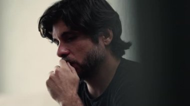 Endişeli genç adam zihinsel olarak stres ve kaygı içinde. Endişeli erkek kişi gelecek için endişeli hissediyor. Duygusal acıdan muzdarip bir adamın yakın plan yüzü
