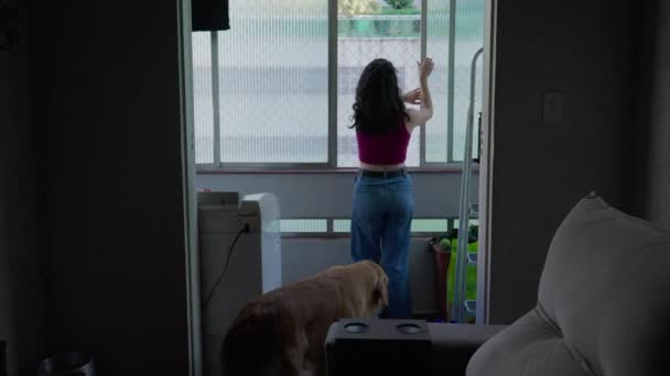 一个年轻女子和她的家犬站在阳台上的公寓窗户里 她的生活方式十分奢华 — 图库视频影像