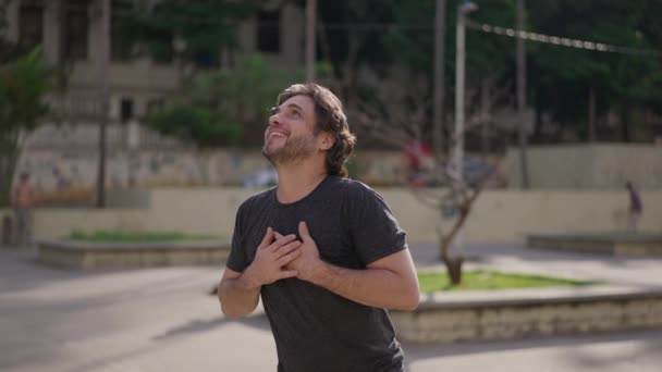 Ευγνώμων Νεαρός Άνδρας Στέκεται Εξωτερικούς Χώρους Κοιτάζοντας Ψηλά Στον Ουρανό — Αρχείο Βίντεο