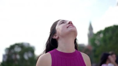 Umut dolu genç bir kadın şehrin dışında dururken Tanrı 'nın lütfunu hissediyor. 30 'lu yaşlardaki inançlı kadın. Daha yüksek bir güce inanıyor. Ellerini göğsüne koyuyor.