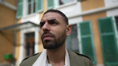 Yüzü düşünceli bir Arap 'a benziyor. Düşünceli bir erkek dışarıda derin derin düşüncelere dalmış bir şekilde bekliyor.