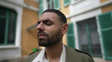 Yüzü düşünceli bir Arap 'a benziyor. Düşünceli bir erkek dışarıda derin derin düşüncelere dalmış bir şekilde bekliyor.