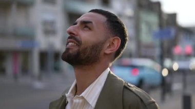 Gün batımında gökyüzüne bakan umut dolu yüzüyle mutlu bir Arap 'ın yakın plan portresi..