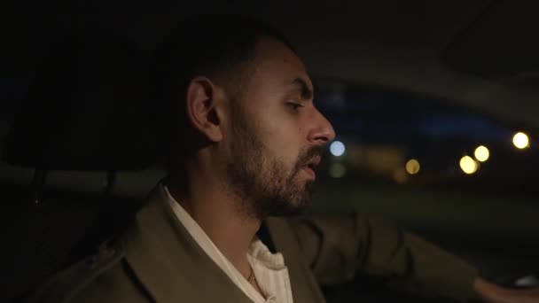 Ένας Άνδρας Από Μέση Ανατολή Οδηγεί Αυτοκίνητο Στο Δρόμο Νύχτα — Αρχείο Βίντεο