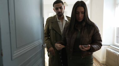 Çift evi terk ediyor. İnsanlar evden çıkmaya hazırlanıyor, dışarı çıkıyorlar.