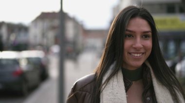 Genç bir Ortadoğulu yetişkin kız kentin sokaklarında gururlu bir ifadeyle yürüyor. Arap bir kadının yakın çekim yüzü.