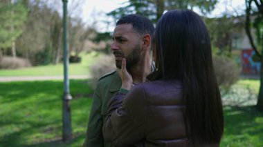 Depresyondaki genç adam parkta bir kadın tarafından avutuluyor. Zihinsel hastalıktan muzdarip umutsuz bir insan yüzünü elleriyle kapatıyor.