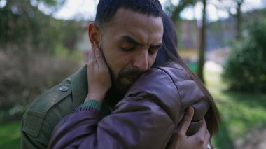 Dışarıda duran bir kadın arkadaş tarafından teselli edilen bir adam kederden muzdarip. Zor zamanlarda empatik sarılma