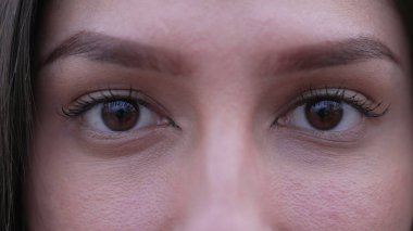 Orta Doğulu genç bir kadın makro gözler ayrıntıları kapatır. Kameraya bakan kadın gözünün aşırı yakın çekimi.