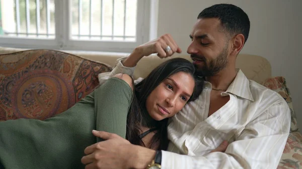 体贴自信的年轻男友抱着女朋友坐在家里的沙发上 男人自信地拥抱女人 — 图库照片