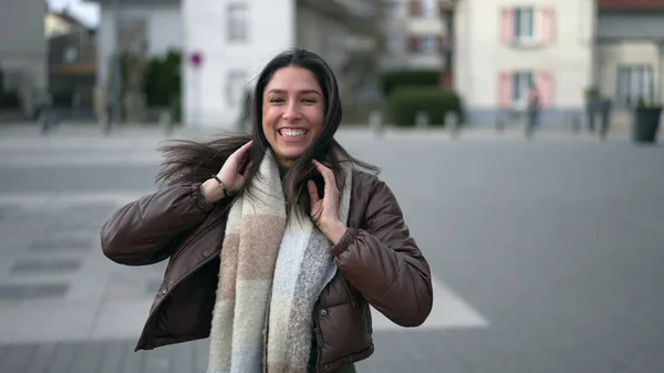 stock image One happy carefree young woman running outside in urban street turning head toward camera in slow motion and smiling