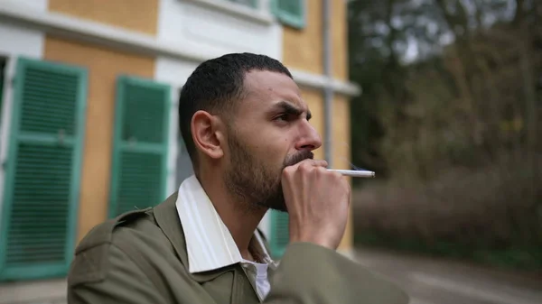 一个忧心忡忡的中东年轻人 带着沉思的表情在外面抽烟 在冥想的过程中跟踪镜头的近视面朝运动 — 图库照片