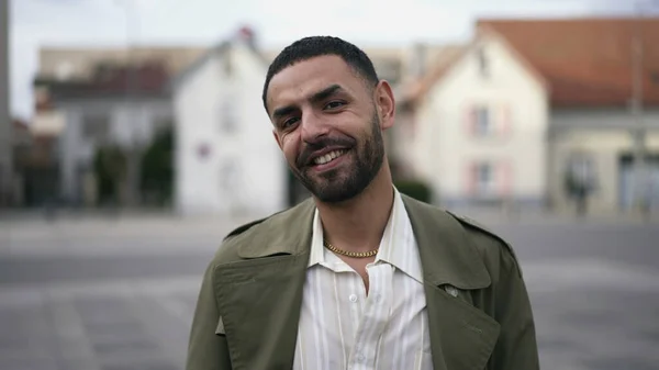 stock image Portrait of a friendly happy young Arab man smiling at camera while standing outside in city street