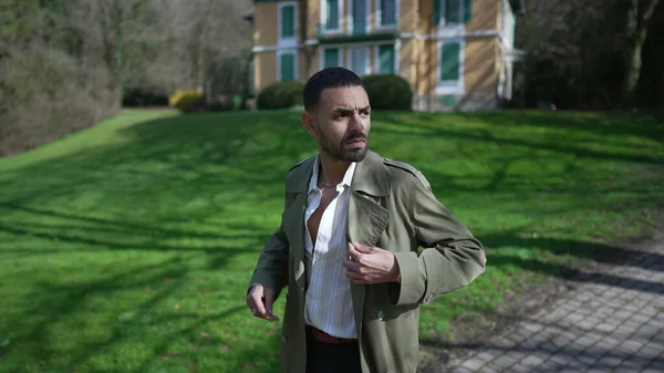 一个自信的中东年轻人穿着时髦的夹克走在公园外面 一个表情严肃的阿拉伯男人走在室外 — 图库照片
