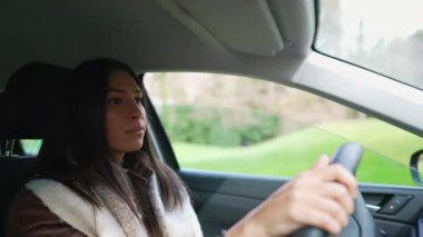 Orta Doğulu genç bir kadın araba kullanıyor. 20 'li yaşlarda kadın sürücü yetişkin bir kızın dahili araç perspektifi.