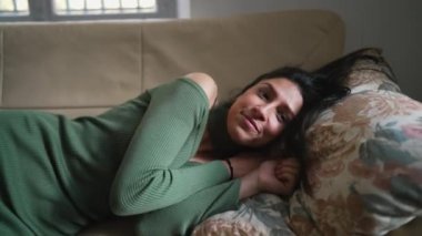 Genç bir Orta Doğulu kadın kanepeye uzanmış dinleniyor ve dinleniyor. Yetişkin bir Arap kızı kendini rahatlamış hissediyor.