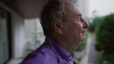 Dairenin balkonunda dikilip bakan dalgın bir son sınıf öğrencisinin arkasında. 70 'li yaşlarda bir erkek akşamları hayatı düşünüyor.