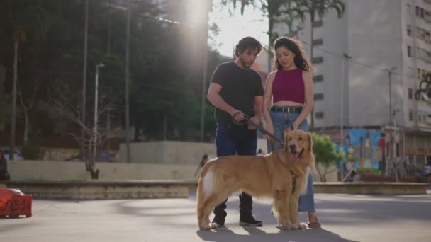 城市里的一对夫妇 一个带着他们心爱的纯金猎犬的糖果户外千禧年 人们和他们的宠物狗的真正的周末活动 — 图库视频影像