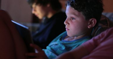 Geceleri tablet aygıtında video oyunu oynayan çocuk