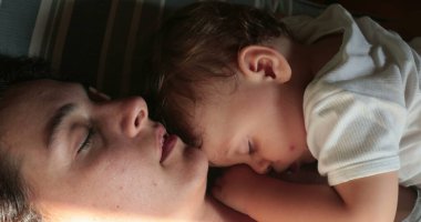 Exhausted tired mother sleeping with infant baby child together